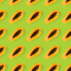 Fresh ripe papaya seamless pattern on green background. Tropical abstract background. Top view. Creative design, minimal flat lay concept. Trend tropical fruit food background pattern