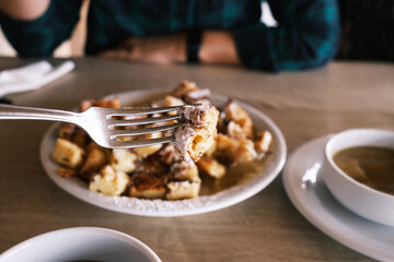 fork picking piece of sweet cut-up pancake with raisins Kaiserschmarrn