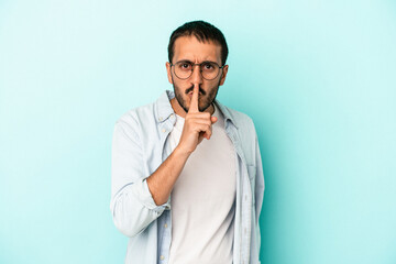 Young caucasian man isolated on blue background keeping a secret or asking for silence.