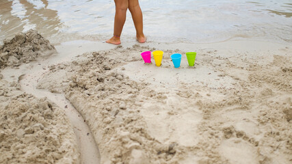 Colorful plastic cones toys on the sand of a beach shore