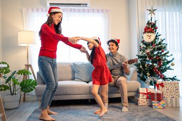 Asian happy family member enjoy sing Christmas song and dance together. 