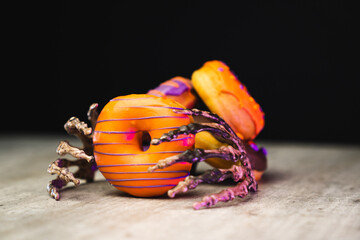multicolored halloween donuts with scary skeleton holding