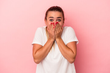 Young Russian woman isolated on pink background shocked, covering mouth with hands, anxious to discover something new.