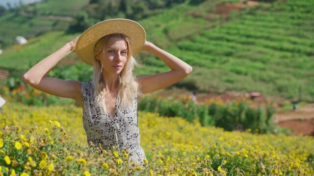 Blonde woman model posing in field of yellow flowers, Mon Jam Thailand