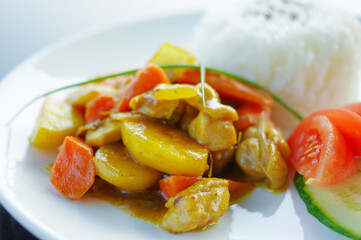 delicious chicken curry with chopped carrot potatoes and black sesame on rice close up view