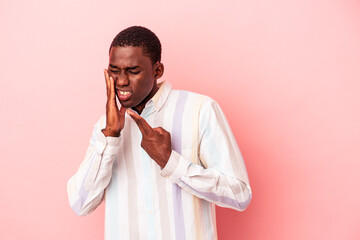 Young African American man isolated on pink background having a strong teeth pain, molar ache.