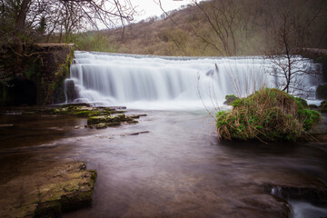 Long exposure of the Monsal Dale Weir waterfall and River Wye on the Monsal Trail in the Peak District