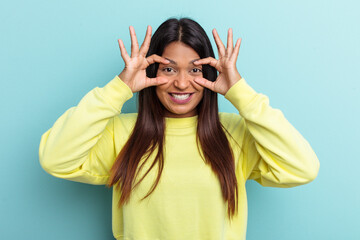 Young Venezuelan woman isolated on blue background keeping eyes opened to find a success opportunity.