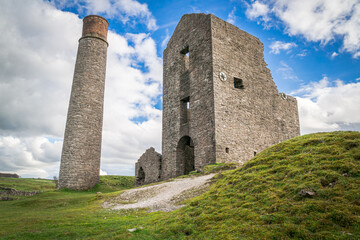 Fototapeta na wymiar The Cornish engine house and circular chimney, at Magpie Mine, Sheldon, a preserved lead mine in the Peak District National Park
