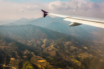 Aerial view for small Nepal villages from the airplane porthole, the plane is landing. Travel...