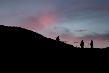 People silhouette walking on the hiking trail during sunset at bird Island Runde.