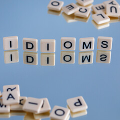 idioms - word from plastic blocks with letters and reflections, mode of expression concept, random...