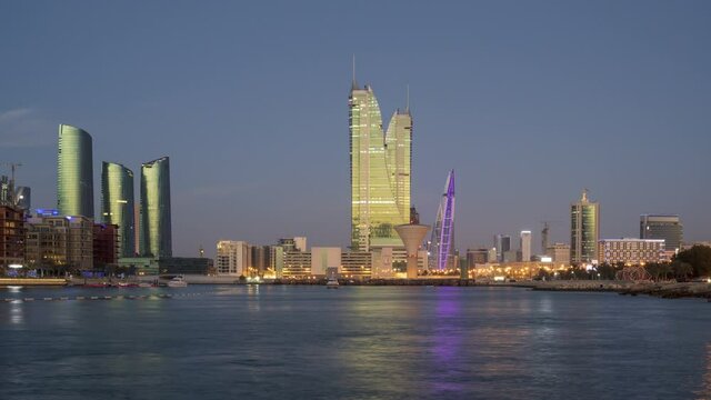 Day to Night 4K Time lapse video of Manama Skyline and Bahrain Financial Harbour, Harbour Heights, Bahrain World Trade Center buildings from Manama City, Bahrain