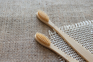 Natural bamboo toothbrushes on rustic background with copy space. Sustainable lifestyle, bathroom essentials in zero waste home. Dental health concept. Selective focus, mockup