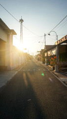 Ponorogo, Indonesia - 04 10 2021 : the street in a residential area, on the edge there are houses of residents lined up and close together, and there is a sunrise.