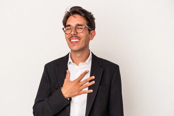 Young mixed race business man isolated on white background laughs out loudly keeping hand on chest.