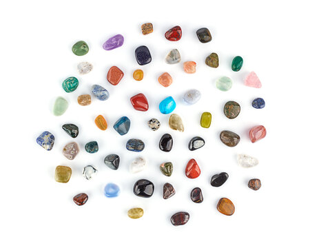 Collection of multicolored minerals and crystals on a white background isolated, top view close-up. Lithotherapy, chakra balancing, crystal ritual.
