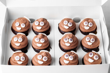Set of cupcakes in the white gift box. Chocolate cupcake with brown cream cheese top decorated with...