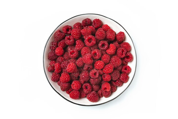 Red raspberry berry in plate on wooden table.