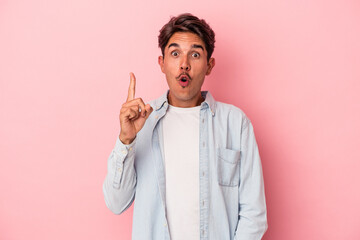 Young mixed race man isolated on white background pointing upside with opened mouth.