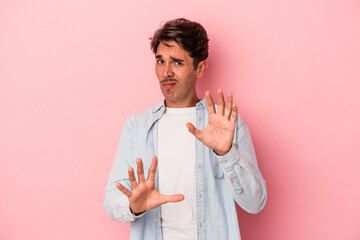 Young mixed race man isolated on white background rejecting someone showing a gesture of disgust.