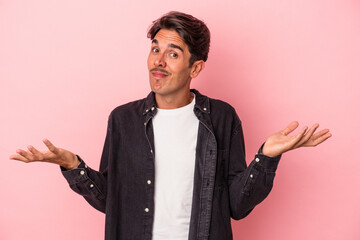 Young mixed race man isolated on white background doubting and shrugging shoulders in questioning...