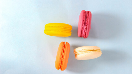 Several colored macarons on a blue background.