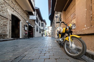 Fototapeta premium cozy streets of kaleichi in antalya motorcycle parked on an empty cozy street. peace and quiet in the historical center of Antalya in Turkey. travel and tourism