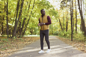 African american student walking in the park in autumn season
