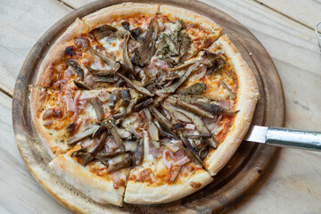 Clean and delicious homemade coriander pizza served on a wooden tray for breakfast and placed on the kitchen table. 