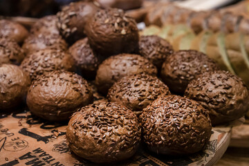 black round buns, sprinkled with grain. fresh pastries, brown little burgers in the bakery