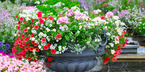 Fototapeta na wymiar Beautiful flower arrangement in a vase in a summer park. Wide photo.
