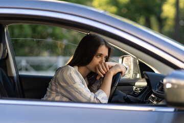 Depressed young woman driver sitting inside car, feeling doubtful confused about difficult decision suffering from personal psychological problem, burnout, quarrel break up with boyfriend, life crisis