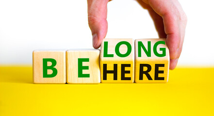 Be here belong symbol. Businessman hand turns cubes and changes words 'be here' to 'belong'. Beautiful white background. Business, belonging and be here belong concept. Copy space.