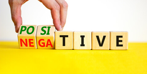 Positive or negative symbol. Businessman turns wooden cubes and changes the word 'negative' to...