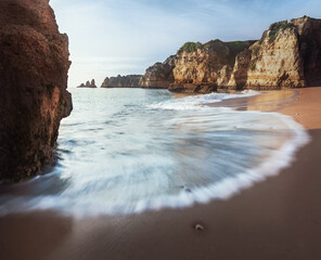 Sea Waves at Praia Dona Ana Beach and Rock formations at sunrise - Long Exposure shot - Lagos, Algarve, Portugal