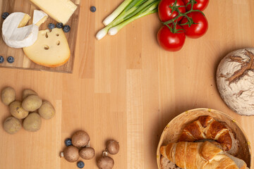 Tisch mit Holz und Käse Holzplatte, mit frischem Brot, Tomaten und Kartoffeln. Traditionelle Brotzeit für gesunde Ernährung. 