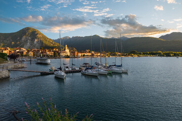 Big Italian lake. Lake Maggiore at sunrise, with the town of Feriolo, moored sailboats and the alps in the background. Northern Italy