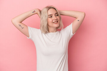 Young caucasian woman isolated on pink background feeling confident, with hands behind the head.