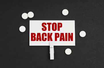 On a black background, there are pills and a business card with the inscription - STOP BACK PAIN