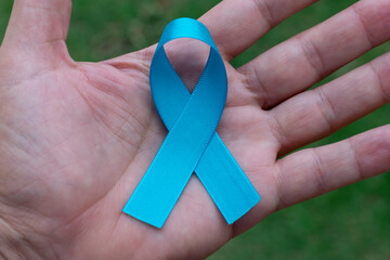 blue ribbon in man's palm. Blue november. Prostate Cancer Prevention Month. Men's health.