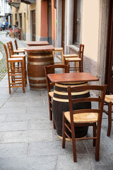 Fototapeta na wymiar Bar tables and chairs on a street terrace in Italy