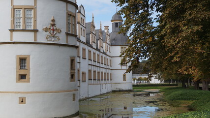 Fototapeta na wymiar a castle shines outside and in the pond in autumn