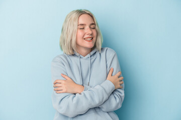 Young caucasian woman isolated on blue background laughing and having fun.