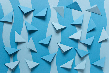 Simple background with folded blue paper triangles on blue paper background