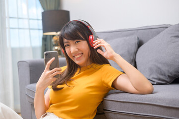 Young happy woman listening to music and relaxing at home