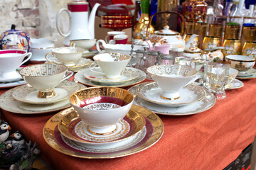 Antiques on flea market or festival - vintage porcelain tea cups, tableware and other vintage...