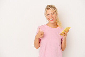 Young Russian woman holding mobile phone isolated on white background smiling and raising thumb up