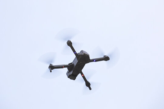 Drone volant vu du dessous sur fond de ciel