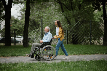 Daughter and disabled father on a walking path